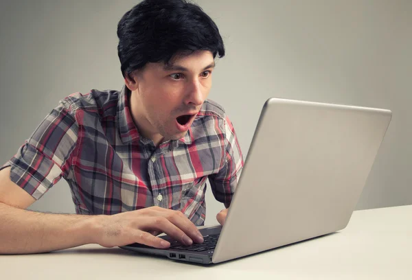 Shocking man reading message on laptop computer — Stock Photo, Image