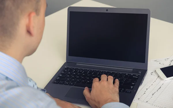 Rear view closeup of a young man working of a laptop — Stock Photo, Image