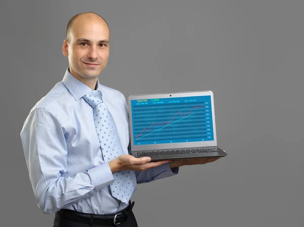 Analyst presenting financial graph on a laptop screen Stock Image