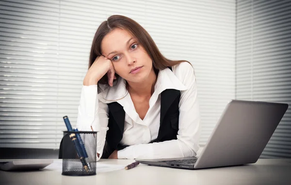 Moe jonge zakenvrouw met laptopcomputer op kantoor — Stockfoto