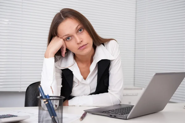Tired young business woman with laptop computer at the office — Stock Photo, Image