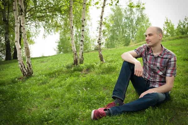 Jonge man ontspannen in de zomer park — Stockfoto