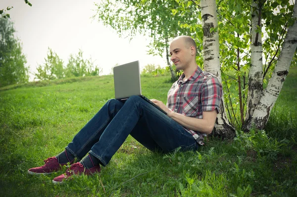Ung man med laptop utomhus — Stockfoto