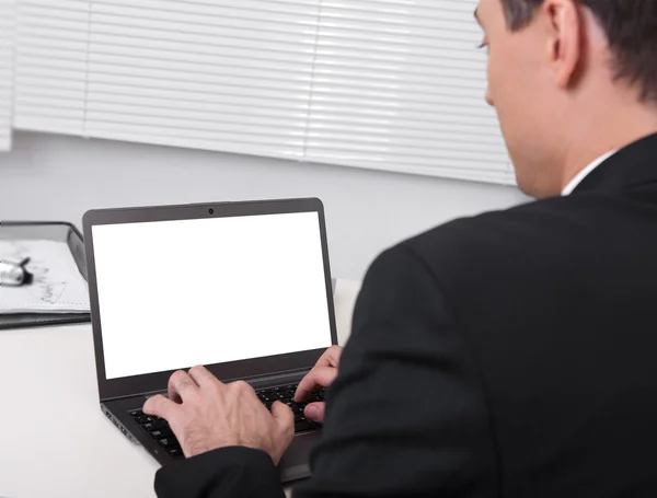 Rückansicht von Geschäftsmann, der am Schreibtisch mit Laptop beschäftigt ist — Stockfoto