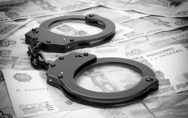 Financial crime. Steel handcuffs and money — Stock Photo, Image