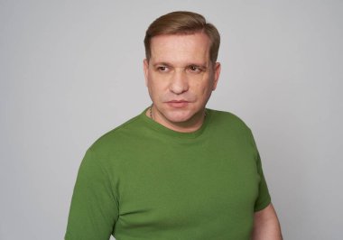 Studio portrait of a middle aged handsome male in green t-shirt