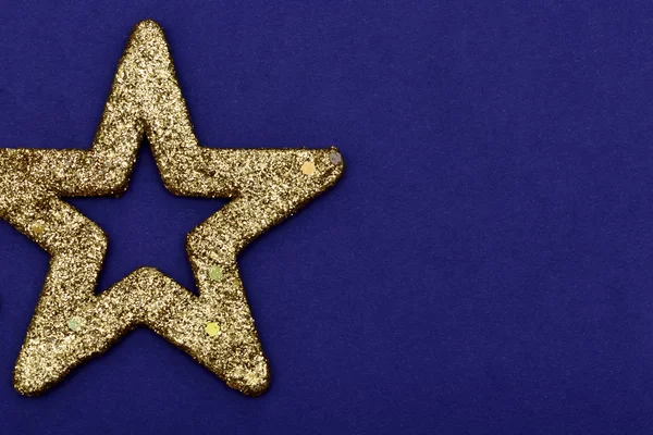 Altın Parıltılı yıldız Noel süs üzerinde mavi bir bac izole — Stok fotoğraf