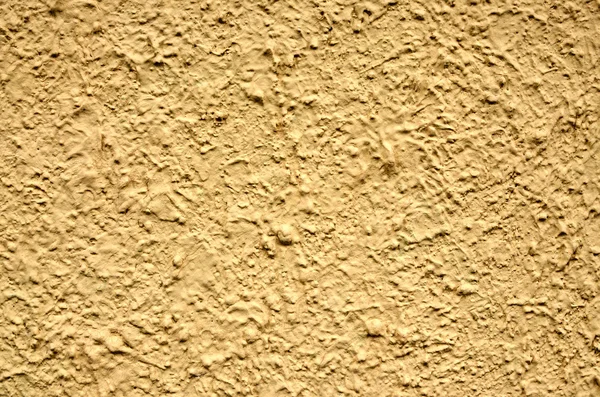 Una pared de estuco amarillo útil para fondos o texturas — Foto de Stock