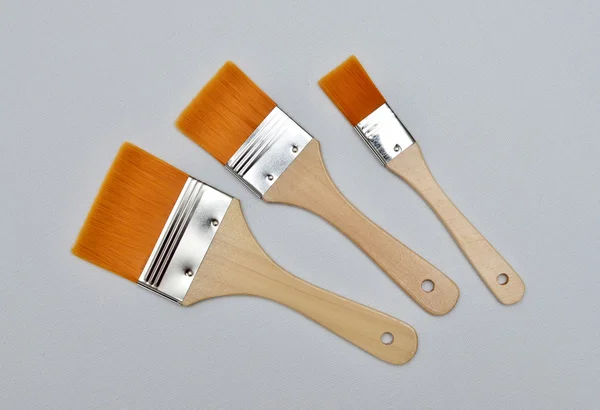 New paint brushes on canvas background — Stock Photo, Image