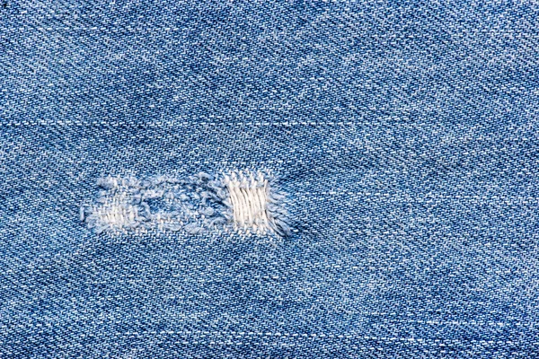 Textur der blauen Jeans zerrissenen Stoff — Stockfoto