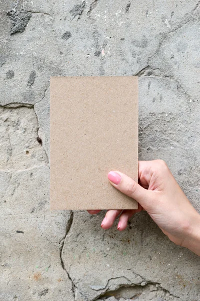 Вітальна листівка в руці жінки на фоні стіни — стокове фото
