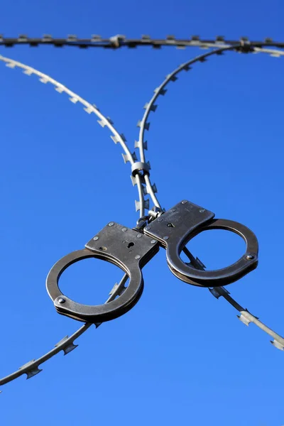 Old Metal Handcuffs Hanging Razor Wire Blue Sky — Stock Photo, Image