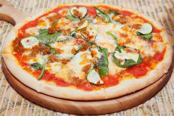 Pizza på ett bräde — Stockfoto