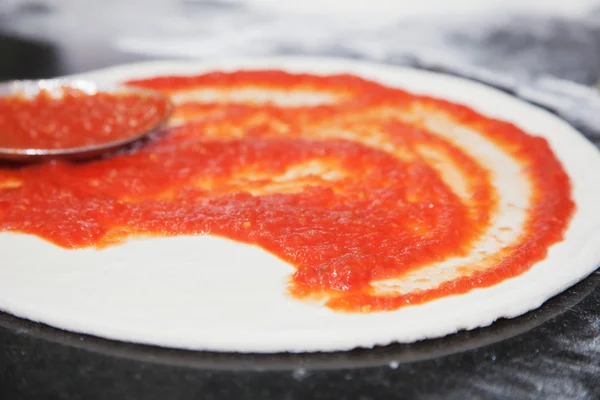 Dough with tomato sauce — Stock Photo, Image