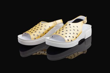 Sarı, şık, rahat, siyah arka planda kadın sandaletleri