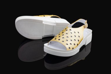 Sarı, şık, rahat, siyah arka planda kadın sandaletleri