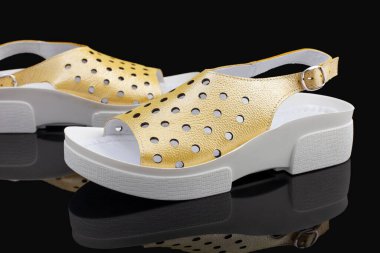 Sarı, şık, rahat, siyah arka planda kadın sandaletleri