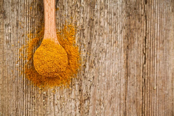 Curry powder in wooden spoon — Stock Photo, Image