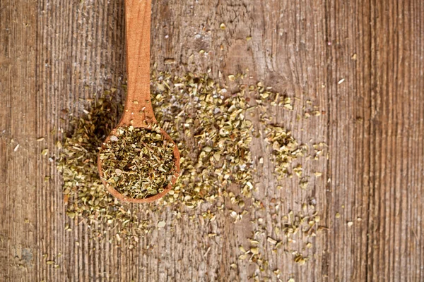 Dry oregano in wooden spoon — Stock Photo, Image