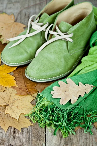 Botas de cuero, bufanda y hojas amarillas — Foto de Stock