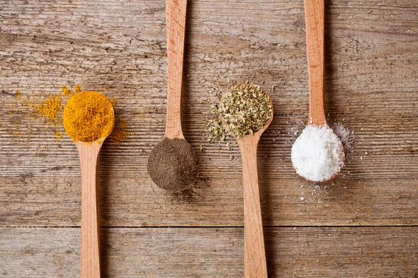 Curry, peppar, oregano och matlagning salt i träskedar — Stockfoto