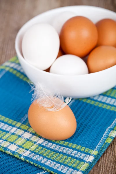 Eier in einer Schüssel, Handtuch und Federn — Stockfoto