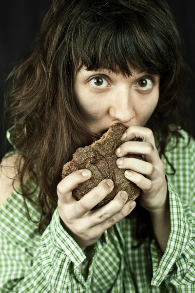 Arme bedelaar vrouw eten brood — Stockfoto