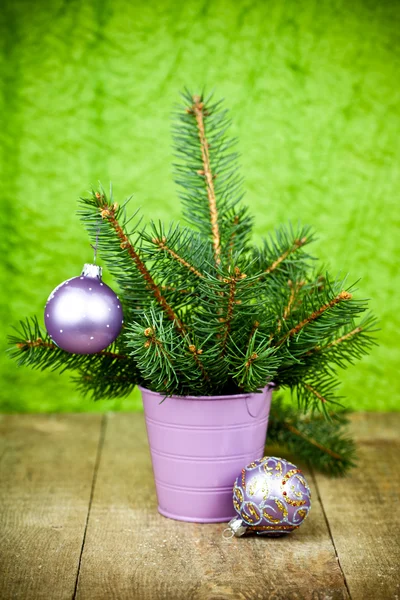 Bucket with christmas fir tree and purple decorations — Stock Photo, Image