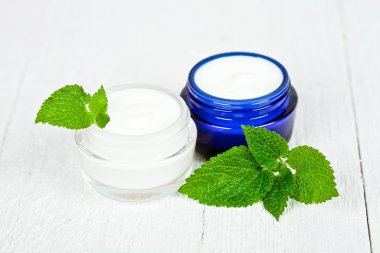 face cream in jars with urtica leaves clipart