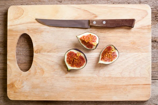 Figs and old knife on wooden board — Stock Photo, Image