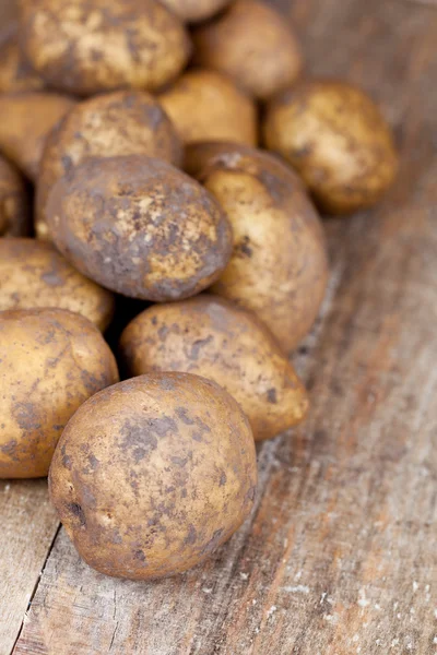 Batatas em um fundo de madeira — Fotografia de Stock