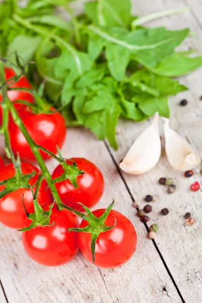 Fresh tomatoes, rucola, garlic and peppercorns — Stock Photo, Image