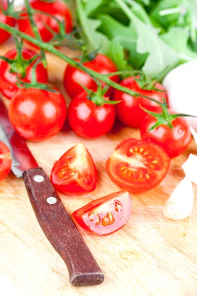 Fresh tomatoes, rucola, garlic and old knife — Stock Photo, Image