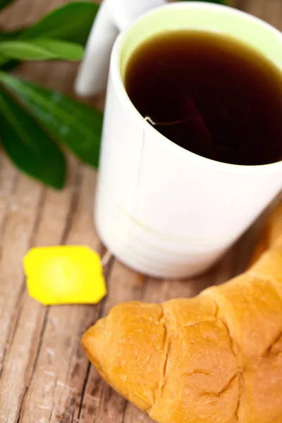 Xícara de chá e croissant fresco — Fotografia de Stock