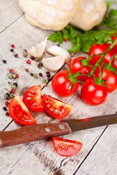 Fresh tomatoes, buns, spices and old knife — Stock Photo, Image