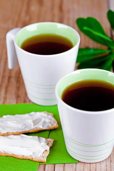 Twee kopjes thee en crackers met roomkaas — Stockfoto