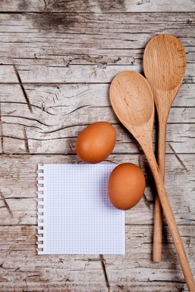 Huevos, cucharas y papel en blanco —  Fotos de Stock