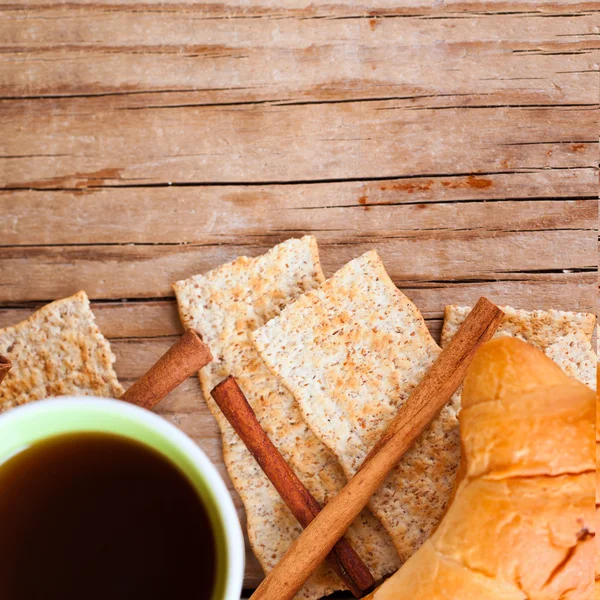 Kopje koffie, crackers en verse croissants voor het ontbijt — Stockfoto