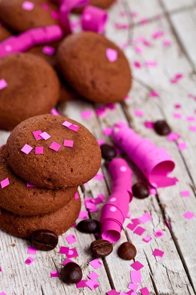 Galletas de chocolate, granos de café, cintas rosas y confeti —  Fotos de Stock