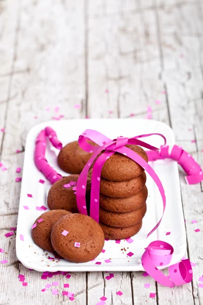 Piatto di biscotti al cioccolato fresco con nastro rosa e confetti — Foto Stock