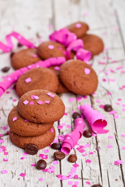 Fresh chocolate cookies, coffee beans, pink ribbons and confetti — Stock Photo, Image