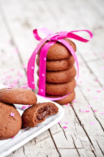 Plato de galletas de chocolate fresco con cinta rosa y confeti —  Fotos de Stock