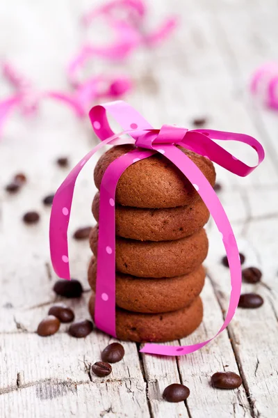 Pila di biscotti al cioccolato legati con nastro rosa e chicco di caffè — Foto Stock