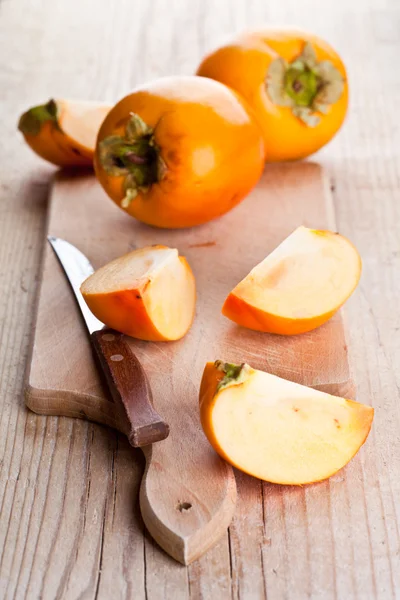 Ripe persimmons and knife — Stock Photo, Image