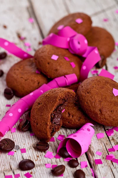 Galletas de chocolate fresco, granos de café, cintas rosas y confeti —  Fotos de Stock