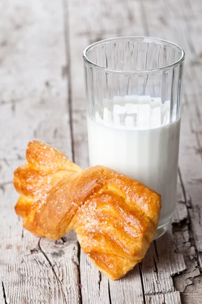 Glas melk en verse gebakken broodje — Stockfoto