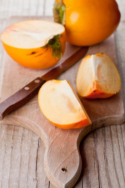 Ripe persimmons and knife — Stock Photo, Image
