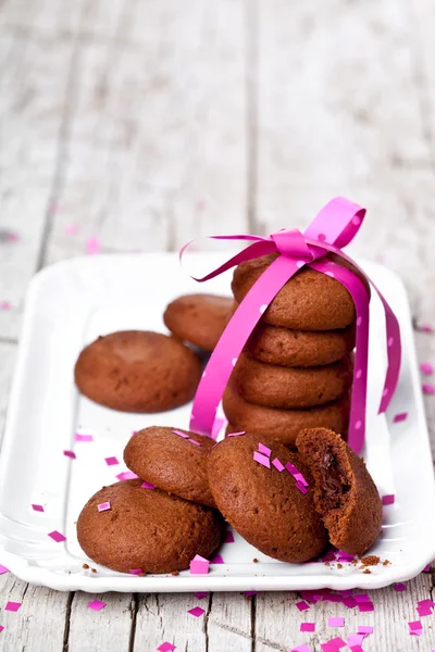Piatto di biscotti al cioccolato fresco con nastro rosa e confetti — Foto Stock