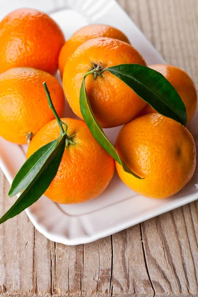 Mandarinas con hojas en placa —  Fotos de Stock