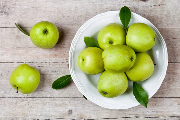 Świeże zielone jabłka w tablicy — Zdjęcie stockowe